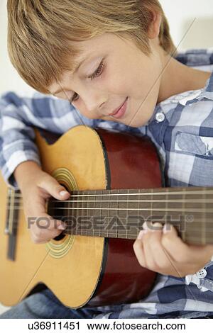 Young boy playing acoustic guitar View Large Photo Image Stock Image - Young boy playing acoustic guitar. Fotosearch
