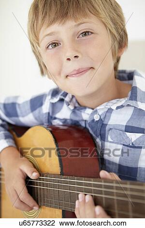 Young boy playing acoustic guitar View Large Photo Image Stock Image - Young boy playing acoustic guitar. Fotosearch