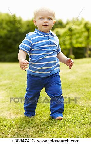 Stock Image - Young Boy Playing In Summer Garden. Fotosearch
