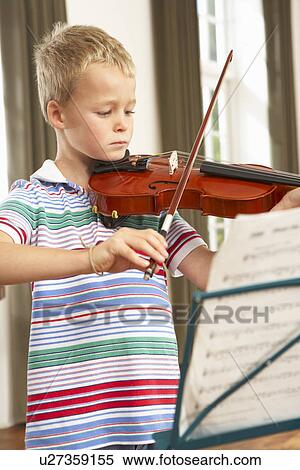 Stock Photography - Young boy playing violin at home. Fotosearch