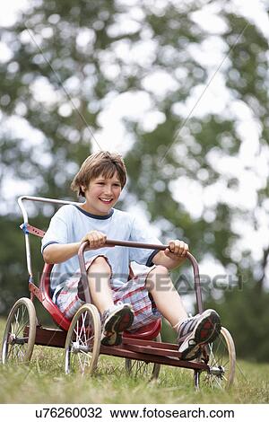 Stock Image - Young boy playing with go-kart. Fotosearch