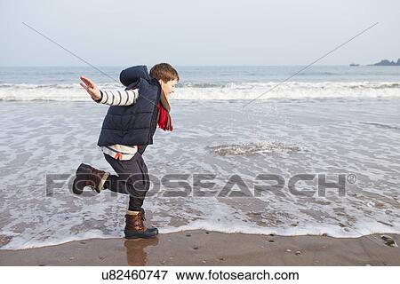 Young Boy Running Along Winter Beach View Large Photo Image Stock Photo - Young Boy Running Along Winter Beach. Fotosearch