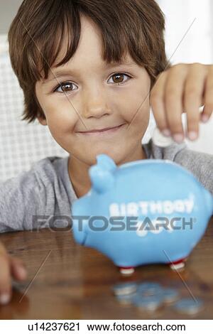 Stock Image - Young boy with piggy bank. Fotosearch