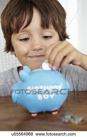 Stock Photo - Young boy with piggy bank. Fotosearch