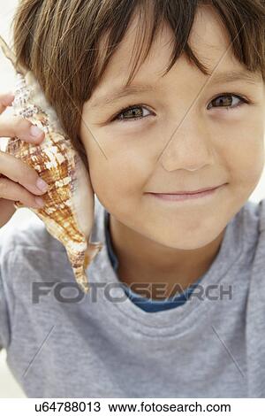 Young boy with seashell View Large Photo Image Stock Image - Young boy with seashell. Fotosearch