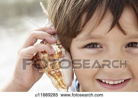 Stock Photography - Young boy with seashell. Fotosearch