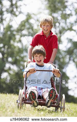 Young boys playing with go-kart View Large Photo Image Stock Image - Young boys playing with go-kart. Fotosearch