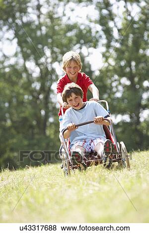 Young boys playing with go-kart View Large Photo Image Stock Photo - Young boys playing with go-kart. Fotosearch