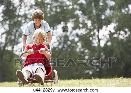Young boys playing with go-kart View Large Photo Image Stock Photo - Young boys playing with go-kart. Fotosearch