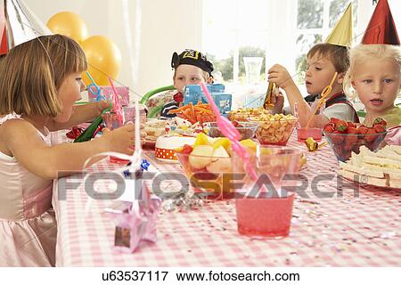 Young children eating at birthday party View Large Photo Image Stock Photo - Young children eating at birthday party. Fotosearch