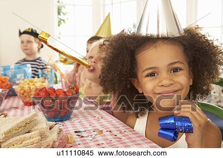 Stock Photography - Young children eating at birthday party. Fotosearch