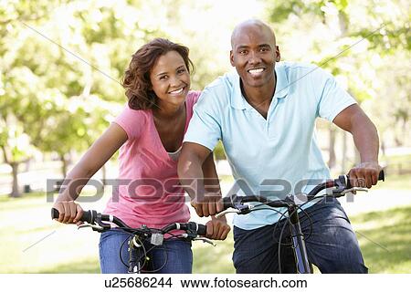 Picture - Young couple cycling in park. Fotosearch
