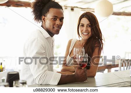 Young Couple Enjoying Drink At Outdoor Bar View Large Photo Image Stock Image - Young Couple Enjoying Drink At Outdoor Bar. Fotosearch