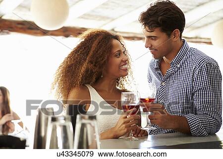Young Couple Enjoying Drink At Outdoor Bar View Large Photo Image Stock Photo - Young Couple Enjoying Drink At Outdoor Bar. Fotosearch