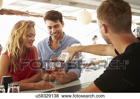 Young Couple Enjoying Drink At Outdoor Bar View Large Photo Image Stock Photo - Young Couple Enjoying Drink At Outdoor Bar. Fotosearch