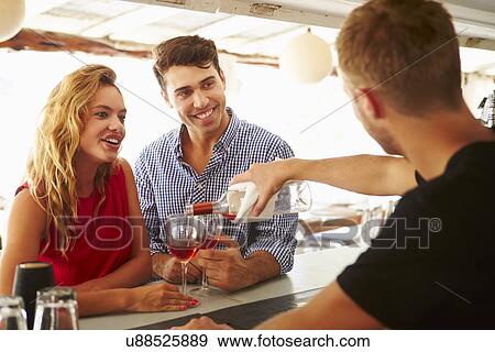 Young Couple Enjoying Drink At Outdoor Bar View Large Photo Image Stock Photo - Young Couple Enjoying Drink At Outdoor Bar. Fotosearch