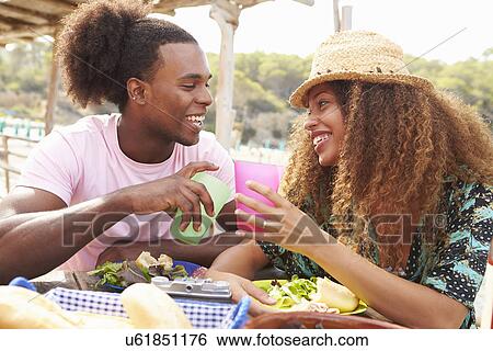 Stock Photograph - Young Couple Enjoying Lunch Outdoors Together. Fotosearch