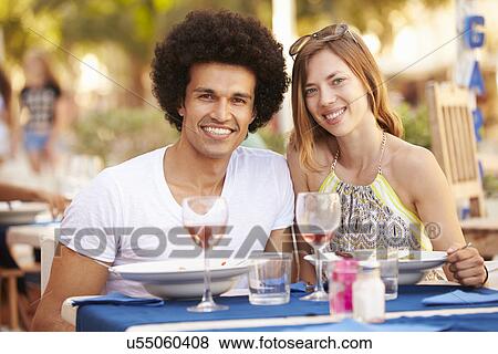 Stock Photo - Young Couple Enjoying Meal In Outdoor Restaurant. Fotosearch