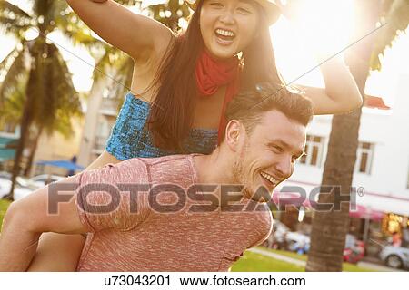 Stock Image - Young Couple Having Fun In Park Together. Fotosearch