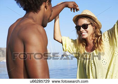 Stock Photo - Young Couple Having Fun In Sea Together. Fotosearch