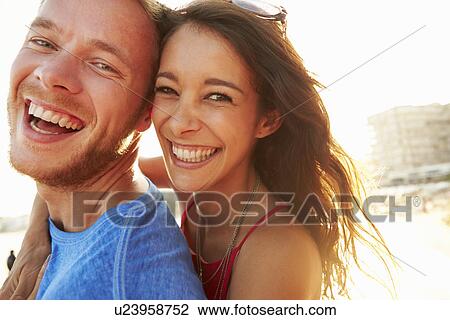 Stock Image - Young Couple Having Fun On Beach Holiday Together. Fotosearch