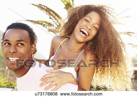 Young Couple Having Fun On Beach Holiday Together View Large Photo Image Stock Photo - Young Couple Having Fun On Beach Holiday Together. Fotosearch