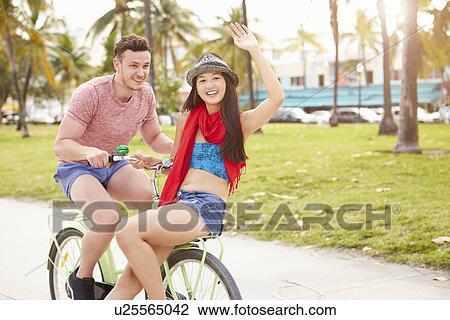 Stock Image - Young Couple Having Fun On Bicycle Ride. Fotosearch