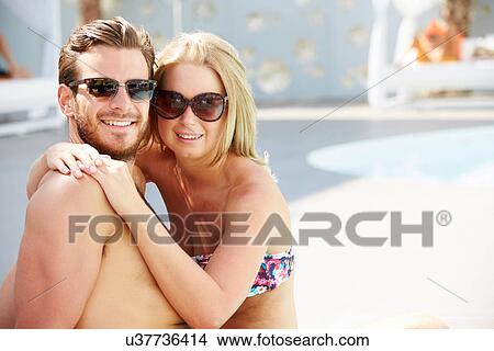 Young Couple On Holiday Relaxing By Swimming Pool View Large Photo Image Picture - Young Couple On Holiday Relaxing By Swimming Pool. Fotosearch