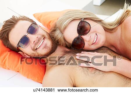 Young Couple On Holiday Relaxing By Swimming Pool View Large Photo Image Stock Image - Young Couple On Holiday Relaxing By Swimming Pool. Fotosearch