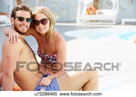 Young Couple On Holiday Relaxing By Swimming Pool View Large Photo Image Stock Photography - Young Couple On Holiday Relaxing By Swimming Pool. Fotosearch