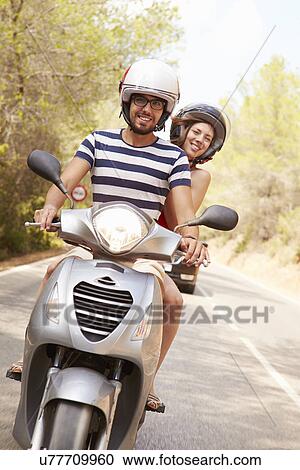 Young Couple Riding Motor Scooter Along Country Road View Large Photo Image Stock Image - Young Couple Riding Motor Scooter Along Country Road. Fotosearch
