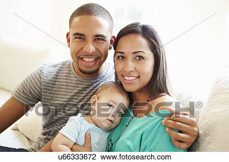 Young Couple Sitting On Sofa Using Digital Tablet View Large Photo Image Stock Image - Young Couple Sitting On Sofa Using Digital Tablet. Fotosearch