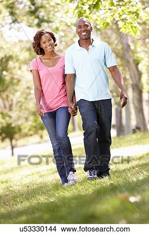 Picture - Young couple walking in park. Fotosearch