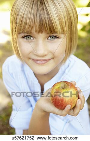 Young girl holding apple View Large Photo Image Stock Image - Young girl holding apple. Fotosearch