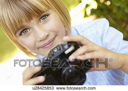 Stock Image - Young girl holding camera. Fotosearch