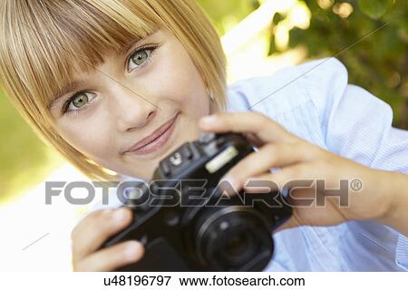Stock Photo - Young girl holding camera. Fotosearch