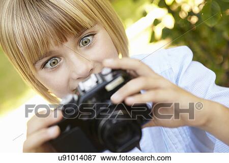 Stock Photo - Young girl holding camera. Fotosearch