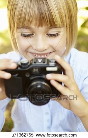Stock Photography - Young girl holding camera. Fotosearch