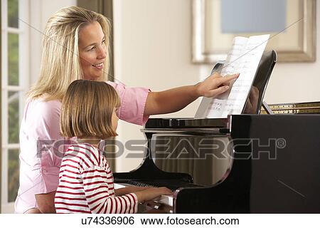 Young girl playing piano in music lesson View Large Photo Image Stock Photograph - Young girl playing piano in music lesson. Fotosearch