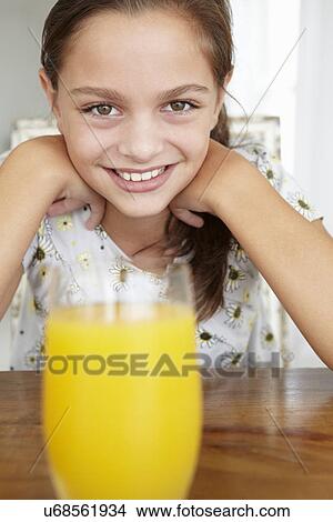 Picture - Young girl with orange juice. Fotosearch