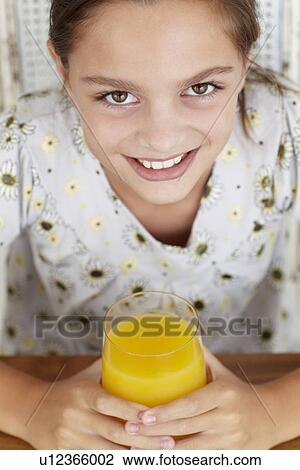 Young girl with orange juice View Large Photo Image Stock Image - Young girl with orange juice. Fotosearch