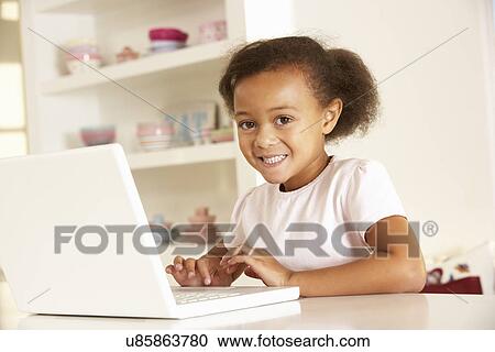 Young girl working on laptop at home View Large Photo Image Stock Image - Young girl working on laptop at home. Fotosearch