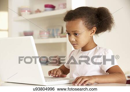 Young girl working on laptop at home View Large Photo Image Stock Photograph - Young girl working on laptop at home. Fotosearch