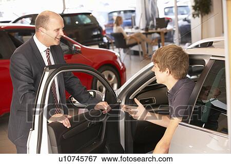 Stock Photo - Young man buying new car. Fotosearch