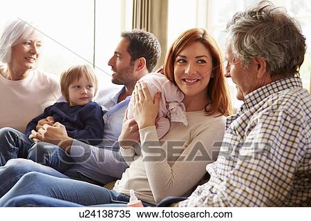 Stock Photography - Young Man Sitting On Roof Terrace Using Laptop. Fotosearch