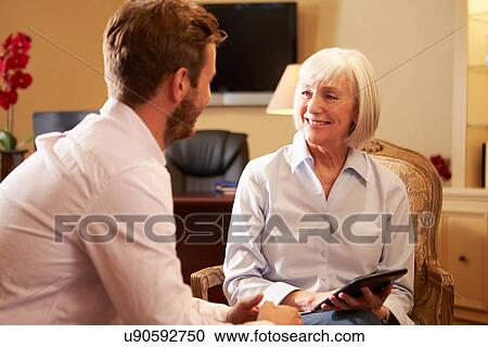 Stock Image - Young Man Talking To Counsellor Using Digital Tablet. Fotosearch