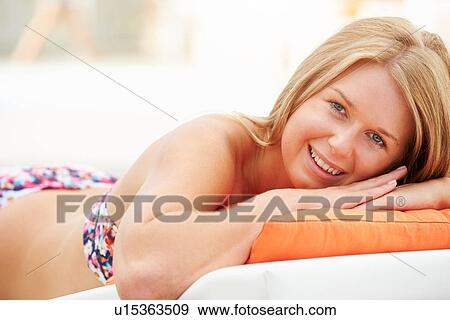 Stock Photo - Young Woman On Holiday Relaxing By Swimming Pool. Fotosearch