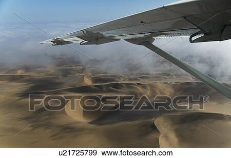 Stock Photo - Aerial view of airplane wing over dunes, Namib Desert, Namibia. Fotosearch