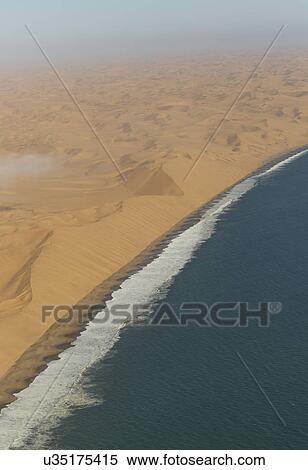 Stock Photography - Aerial view of sea and dunes, Namib Desert, Namibia. Fotosearch