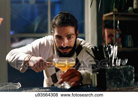 Stock Photo - Bartender serving cocktail at bar. Fotosearch